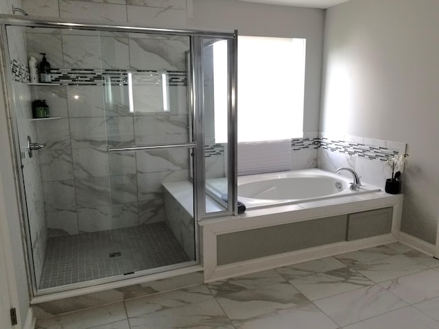 bathroom featuring a stall shower, baseboards, marble finish floor, and a bath