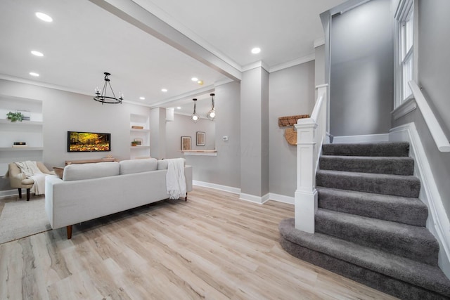 living room with baseboards, stairway, crown molding, and light wood finished floors