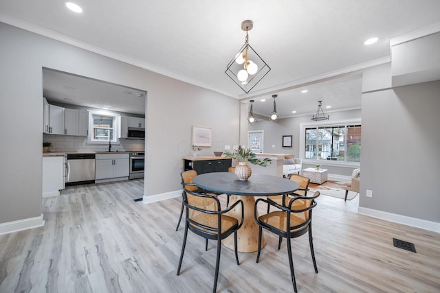 dining area featuring crown molding, baseboards, visible vents, light wood-style floors, and recessed lighting