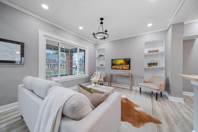 living area with baseboards, built in shelves, crown molding, and light wood-type flooring