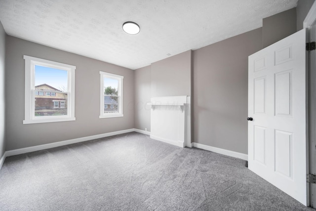 unfurnished bedroom with baseboards, carpet, and a textured ceiling