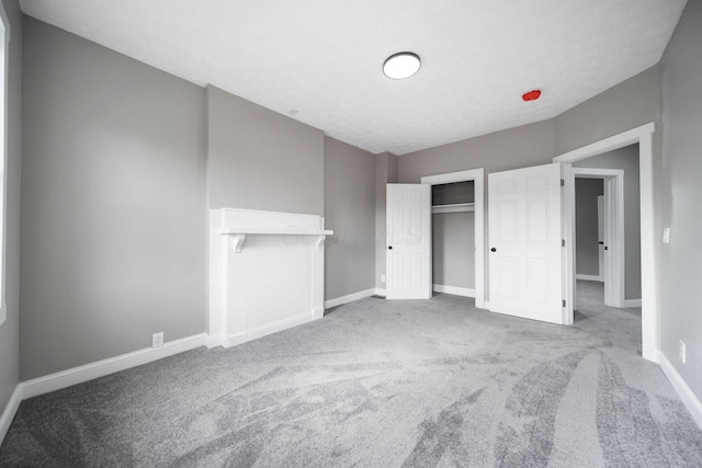unfurnished bedroom featuring carpet floors, baseboards, and a closet