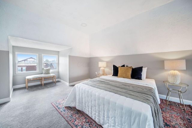bedroom featuring baseboards, lofted ceiling, and carpet