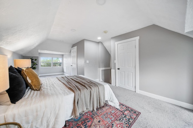 carpeted bedroom with baseboards, lofted ceiling, and a textured ceiling