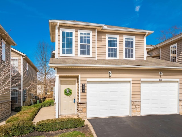 6088 Sowerby Ln, Westerville, OH 43081 - view of front facade with stone siding, a garage, and aphalt driveway