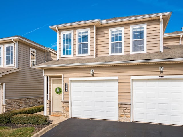 6088 Sowerby Ln, Westerville, OH 43081 - view of front facade featuring stone siding, aphalt driveway, and a garage