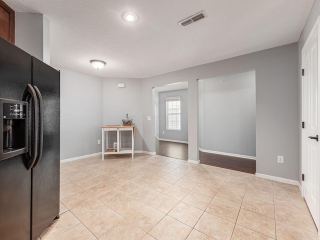 6088 Sowerby Ln, Westerville, OH 43081 - kitchen featuring light tile patterned flooring, a textured ceiling, black fridge, baseboards, and visible vents