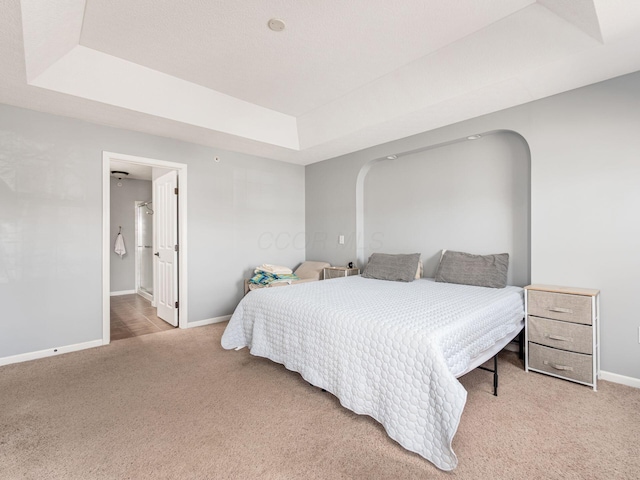 6088 Sowerby Ln, Westerville, OH 43081 - bedroom featuring a raised ceiling, arched walkways, baseboards, and light colored carpet