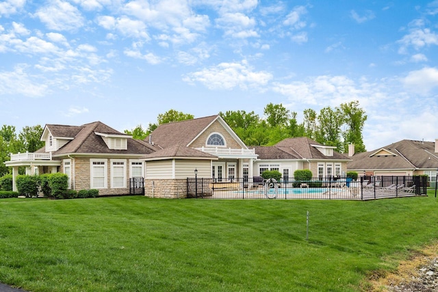 6088 Sowerby Ln, Westerville, OH 43081 - back of house with fence, stone siding, a fenced in pool, a yard, and a patio area