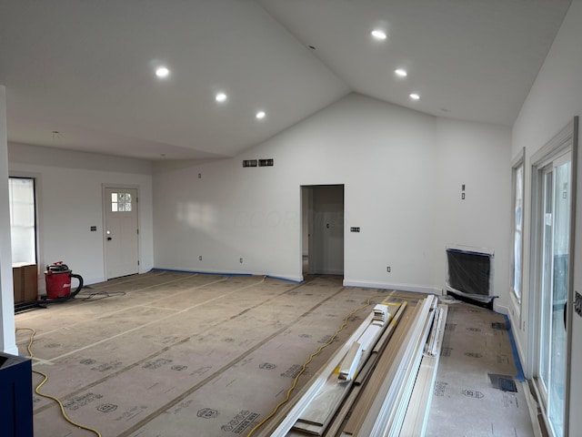 unfurnished living room with visible vents, baseboards, high vaulted ceiling, and recessed lighting
