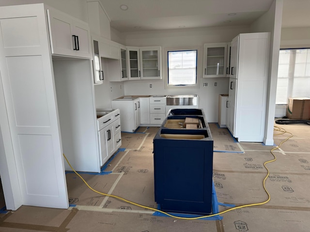 kitchen featuring glass insert cabinets, white cabinets, and a kitchen island