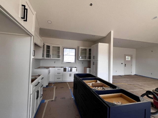 kitchen with glass insert cabinets, white cabinets, and a center island