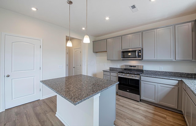 280 Dowler Dr Lot 349, South Bloomfield, OH 43103 - kitchen featuring appliances with stainless steel finishes, gray cabinetry, light wood finished floors, dark stone countertops, and a kitchen island
