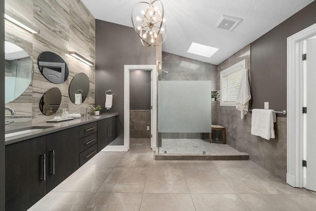 bathroom featuring a sink, tile walls, double vanity, and walk in shower