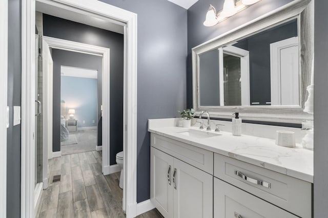 bathroom featuring visible vents, baseboards, toilet, vanity, and wood finished floors