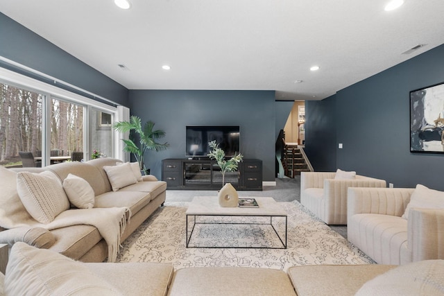 carpeted living area with recessed lighting, stairs, visible vents, and an accent wall