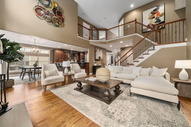 living room with recessed lighting, stairway, a notable chandelier, and wood finished floors