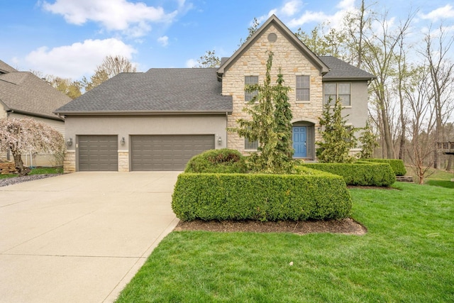 traditional-style house featuring a front yard, an attached garage, stone siding, concrete driveway, and stucco siding