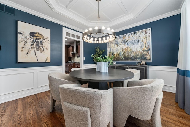 dining room featuring visible vents, an inviting chandelier, ornamental molding, wood finished floors, and a wainscoted wall