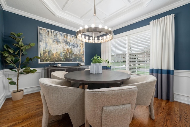 dining area with crown molding, a wainscoted wall, an inviting chandelier, and wood finished floors