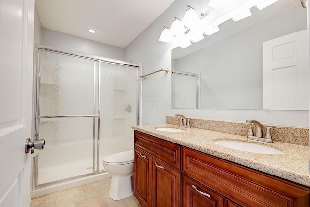 bathroom featuring double vanity, toilet, a shower stall, and a sink