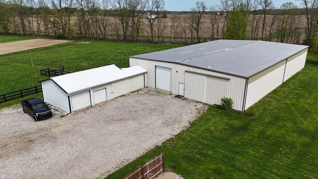 view of outbuilding featuring fence, an outbuilding, and driveway