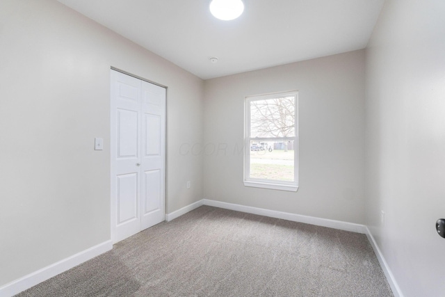 empty room with baseboards and carpet