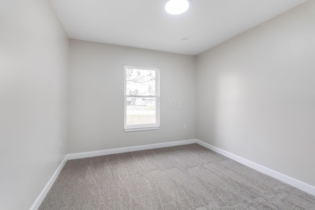 empty room with baseboards and carpet flooring