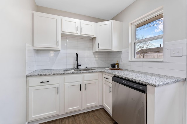 kitchen with dark wood finished floors, stainless steel dishwasher, a sink, light stone counters, and white cabinets