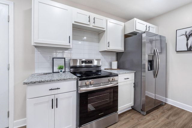 kitchen featuring backsplash, light wood-style flooring, stainless steel appliances, and white cabinetry