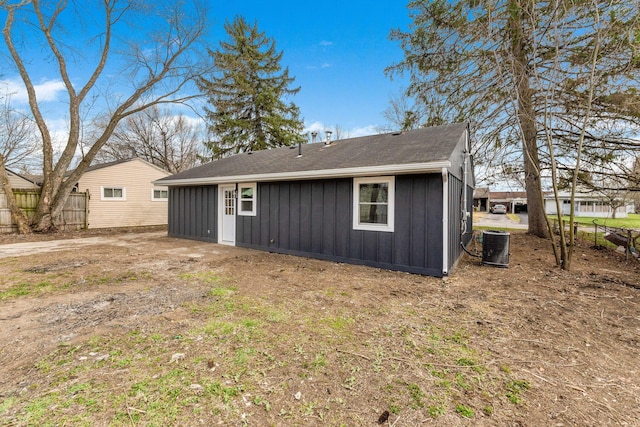 back of house with central air condition unit, fence, and board and batten siding