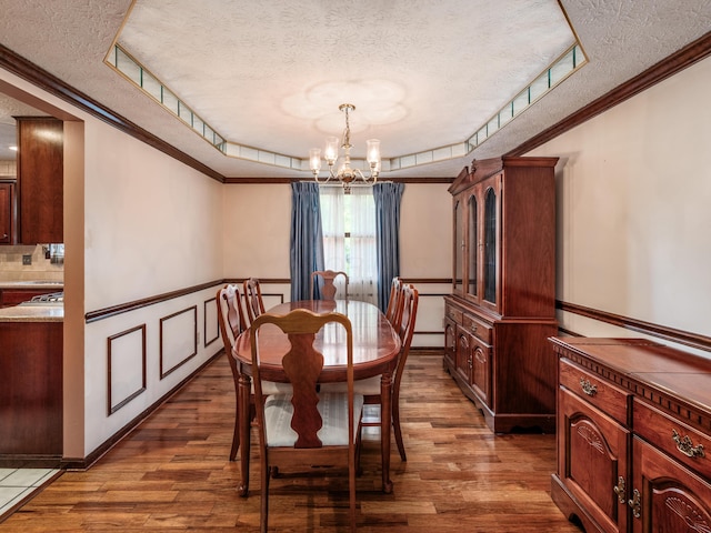 162 Juniper Ave, Westerville, OH 43081 - dining space featuring a textured ceiling, a chandelier, wood finished floors, ornamental molding, and a tray ceiling
