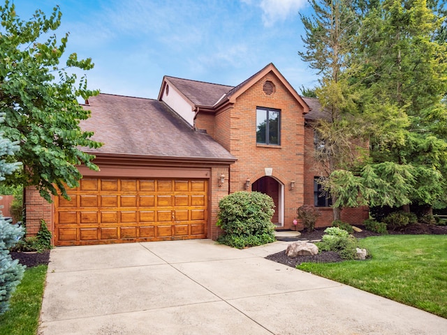 162 Juniper Ave, Westerville, OH 43081 - view of front of house featuring an attached garage, brick siding, roof with shingles, and driveway