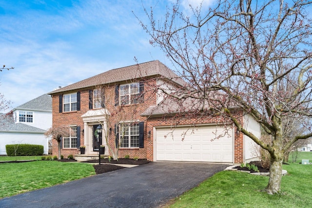 view of front of property with a front lawn, driveway, an attached garage, and brick siding
