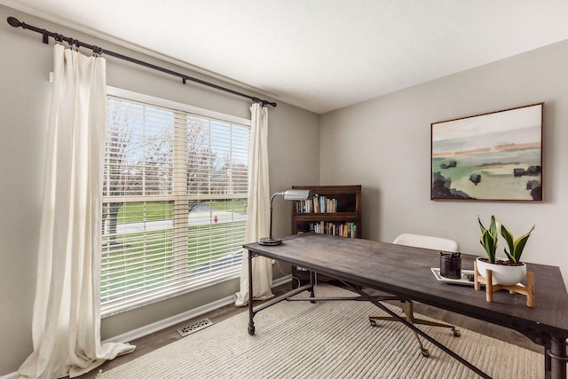 office featuring baseboards, visible vents, and wood finished floors