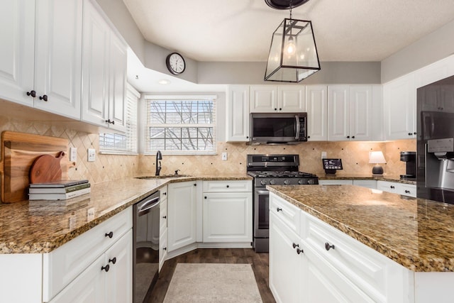 kitchen with tasteful backsplash, appliances with stainless steel finishes, white cabinetry, a sink, and stone counters