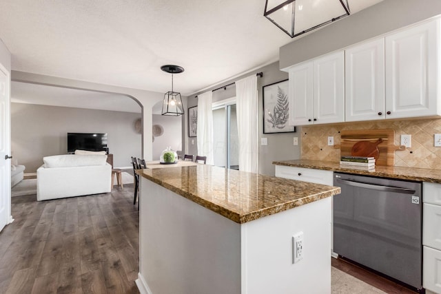 kitchen featuring backsplash, white cabinetry, stainless steel dishwasher, a center island, and dark wood-style flooring