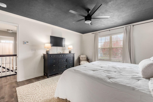 bedroom with crown molding, wood finished floors, and a textured ceiling