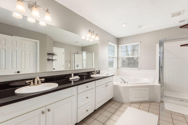full bath with tile patterned floors, a sink, a stall shower, visible vents, and a bath
