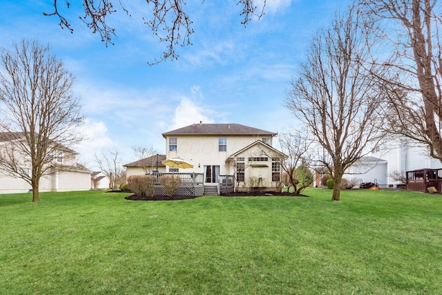 rear view of property with a yard and a wooden deck