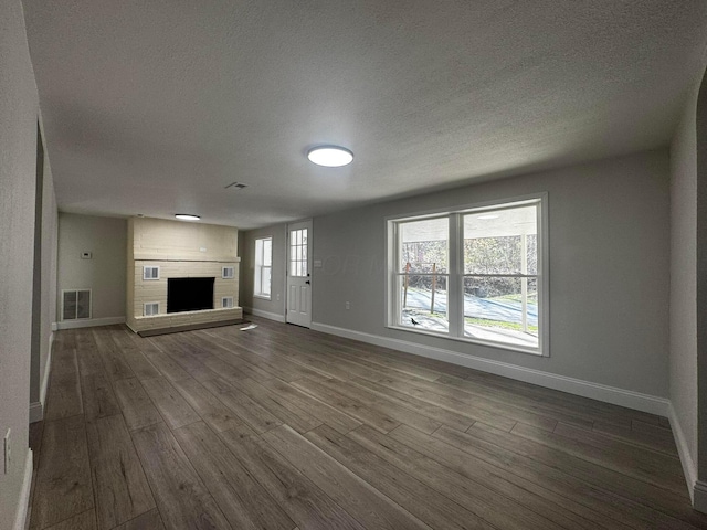 9808 Alderman Rd, Millfield, OH 45761 - unfurnished living room featuring baseboards, visible vents, dark wood-type flooring, and a textured ceiling