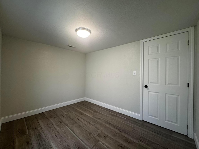 9808 Alderman Rd, Millfield, OH 45761 - empty room featuring dark wood-style flooring, a textured ceiling, baseboards, and visible vents
