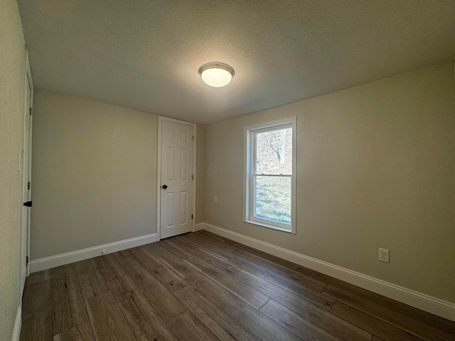 9808 Alderman Rd, Millfield, OH 45761 - empty room featuring a textured ceiling, baseboards, and dark wood finished floors