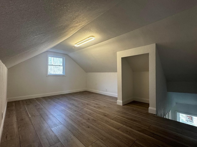 9808 Alderman Rd, Millfield, OH 45761 - bonus room with dark wood-style flooring, baseboards, lofted ceiling, and a textured ceiling