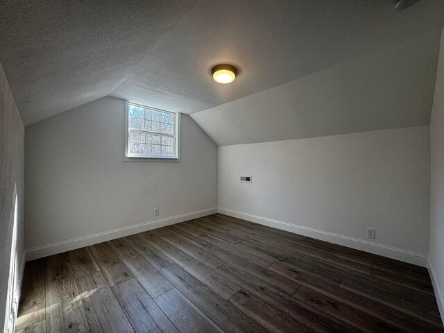 9808 Alderman Rd, Millfield, OH 45761 - additional living space with baseboards, dark wood-style flooring, a textured ceiling, and lofted ceiling