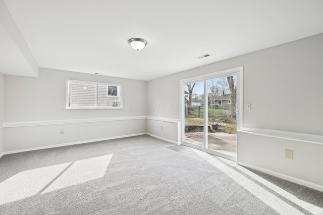carpeted spare room featuring baseboards and visible vents