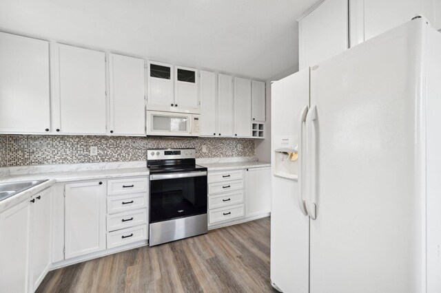 kitchen with white cabinets, wood finished floors, backsplash, and white appliances
