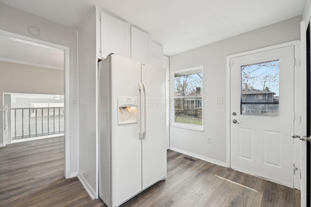 kitchen with white cabinetry, baseboards, dark wood finished floors, visible vents, and white fridge with ice dispenser