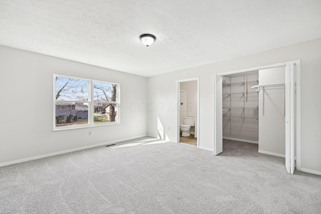 unfurnished bedroom featuring a closet, a textured ceiling, visible vents, baseboards, and carpet floors