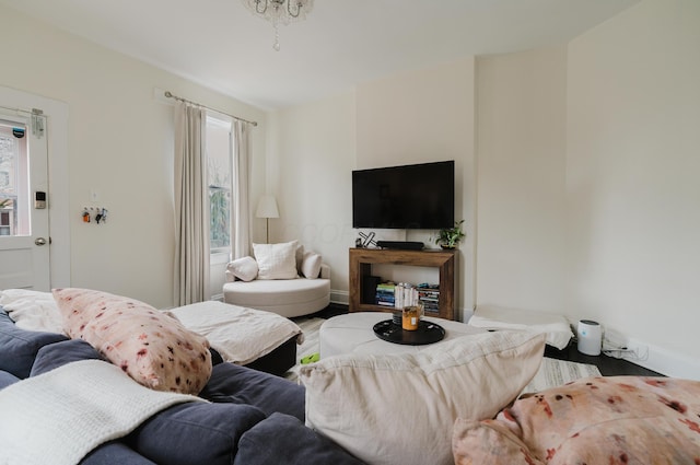 living area with baseboards and wood finished floors